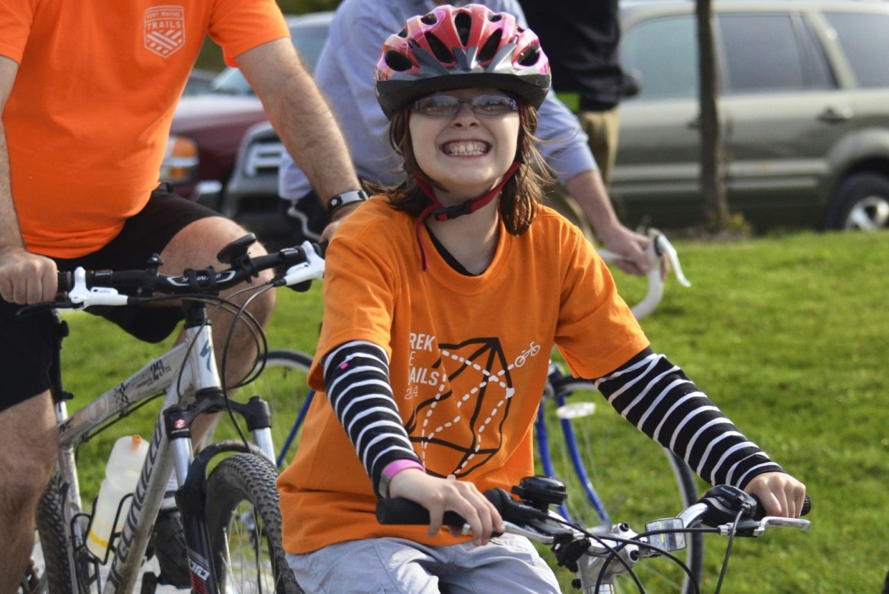 Photo of smiling child on bike