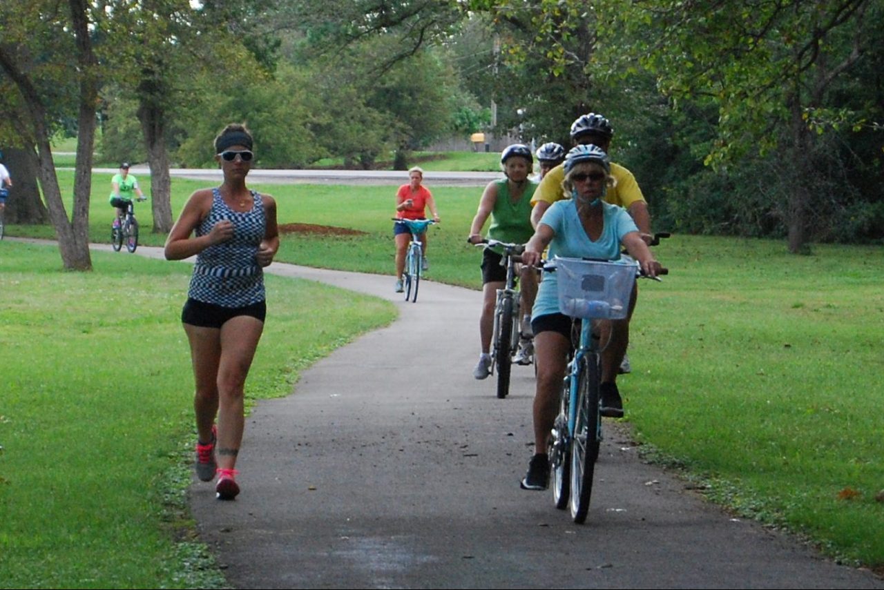 Bicyclists passing jogger on left