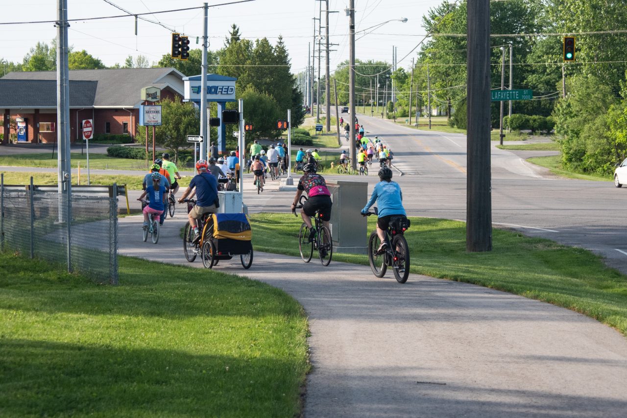 large group of riders crossing layfayette on a trek the trails ride.